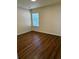 Empty bedroom with wood-look flooring, window, and blinds at 3015 Carnegie Hall Ct, Cumming, GA 30040