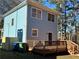 Backyard view of a blue two-story house with a wooden deck and surrounding trees at 941 Capitol View Ave, Atlanta, GA 30318