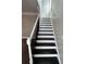 A staircase with dark stained steps and white railings leading to the second floor at 941 Capitol View Ave, Atlanta, GA 30318