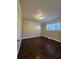 Empty bedroom with dark wood-look floors, neutral walls, and single window at 90 Skyline Dr, Hampton, GA 30228