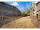 Sloped backyard with retaining wall, dry grass, and trees at 264 Creek View Pl, Canton, GA 30114