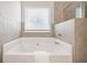 Relaxing bathroom featuring a soaking tub and tiled walls at 264 Creek View Pl, Canton, GA 30114