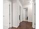 Hallway with white doors, wood-style flooring, and neutral paint at 264 Creek View Pl, Canton, GA 30114