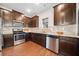 Modern kitchen with stainless steel appliances, dark wood cabinets, and granite countertops at 264 Creek View Pl, Canton, GA 30114