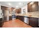 Stylish kitchen boasts stainless steel appliances, dark wood cabinetry, and granite countertops at 264 Creek View Pl, Canton, GA 30114