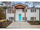 Close-up view of the home's entrance, featuring a teal door and a wooden awning at 4130 Seminole Cir, Austell, GA 30106