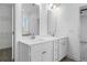 Bright bathroom with double vanity, white cabinets, and modern fixtures at 1495 Auburn Glen Rd, Dacula, GA 30019