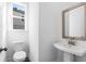 Half bathroom with pedestal sink, toilet, and framed mirror at 1495 Auburn Glen Rd, Dacula, GA 30019