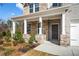 Welcoming front porch with stone accents and a dark-colored front door at 1495 Auburn Glen Rd, Dacula, GA 30019