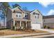 Beautiful new construction home with a stone and brick exterior and a front porch at 1495 Auburn Glen Rd, Dacula, GA 30019
