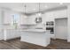 White kitchen with island, stainless steel appliances, and stylish light fixtures at 1495 Auburn Glen Rd, Dacula, GA 30019