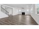 Bright living room with fireplace, wood-look flooring, and staircase at 1495 Auburn Glen Rd, Dacula, GA 30019
