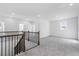 Carpeted loft area with railing overlooking the staircase and access to bedrooms at 1495 Auburn Glen Rd, Dacula, GA 30019