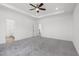 Primary bedroom with gray carpet, ceiling fan, and ensuite bathroom access at 1495 Auburn Glen Rd, Dacula, GA 30019