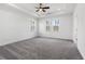 Spacious primary bedroom with gray carpet, tray ceiling, and windows at 1495 Auburn Glen Rd, Dacula, GA 30019