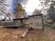 View of the back exterior with a deck, grassy yard, and retaining wall at 1947 Kenwood Pl, Smyrna, GA 30082