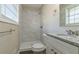 Bathroom with white marble tile shower, granite vanity top, and white toilet at 1347 Peggy Nw Ln, Conyers, GA 30012
