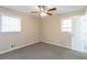 Empty bedroom with neutral walls, gray carpet, ceiling fan, and two windows at 1347 Peggy Nw Ln, Conyers, GA 30012
