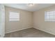 Vacant bedroom with neutral walls, gray carpet, and two windows with blinds at 1347 Peggy Nw Ln, Conyers, GA 30012
