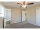 Empty bedroom with neutral walls, gray carpet, ceiling fan, and ensuite bathroom access at 1347 Peggy Nw Ln, Conyers, GA 30012