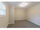 Empty bedroom with neutral walls, gray carpet, and a window with blinds at 1347 Peggy Nw Ln, Conyers, GA 30012