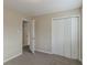 Empty bedroom with neutral walls, gray carpet, a closet, and a partially open door at 1347 Peggy Nw Ln, Conyers, GA 30012