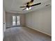 Large primary bedroom with carpeting, tray ceilings, and backyard access at 1745 Wynfield Ln, Auburn, GA 30011