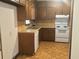 Kitchen features wood cabinets, white appliances, and wood flooring at 3594 Broxton Ln, Snellville, GA 30039