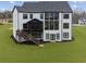 Back of the house with a large screened porch, deck, and numerous windows at 13385 Bishops Ct, Roswell, GA 30075