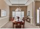 Dining room with tray ceiling, chandelier, large windows, and wooden dining table with chairs at 1545 Great Oaks Dr, Lawrenceville, GA 30045