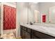 Clean bathroom with dark vanity, white countertop, and red patterned shower curtain at 120 Emerson Trl, Covington, GA 30016