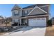 Two-story house with gray siding, stone accents, and a two-car garage at 120 Emerson Trl, Covington, GA 30016