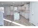 Bright, spacious kitchen featuring white cabinetry, a center island, and wood-look flooring at 10 Barton Ln, Covington, GA 30016