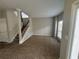 Spacious living room with neutral walls, carpeted flooring, and a staircase leading to the second floor at 6968 Sandtown Ln, Stone Mountain, GA 30087