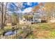 Backyard view of a yellow house with a deck and a small pond at 682 Jockey Ln, Auburn, GA 30011