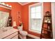 Small bathroom with single sink vanity, toilet, and coral walls at 4754 Ivy Ridge Se Dr # 1, Atlanta, GA 30339