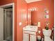 Bathroom with single sink vanity, shower, and coral walls at 4754 Ivy Ridge Se Dr # 1, Atlanta, GA 30339