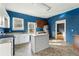 Kitchen with blue walls, white and brown cabinets, and an island at 6214 Hagin St, Douglasville, GA 30134