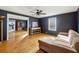 Living area with dark walls, hardwood floors, ceiling fan, and a tan sectional sofa at 6214 Hagin St, Douglasville, GA 30134