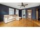 Living room with dark walls, hardwood floors, sectional sofa, and built-in bookcase at 6214 Hagin St, Douglasville, GA 30134