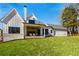 Modern farmhouse exterior with a covered back porch, stone accents, and a lush green lawn at 105 Nova Ln, Roswell, GA 30075