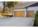 Three-car garage with modern wood-paneled doors and a concrete driveway at 105 Nova Ln, Roswell, GA 30075