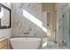 Luxurious main bathroom featuring a freestanding tub, marble tile, and ample natural light at 105 Nova Ln, Roswell, GA 30075