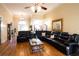 Spacious living room with hardwood floors, a black leather sectional, fireplace, and piano at 907 Hannah Ct, Loganville, GA 30052