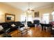 Living room featuring hardwood floors, a fireplace, black leather sectional couch, and a piano at 907 Hannah Ct, Loganville, GA 30052