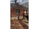 Backyard view with deck, stone retaining wall, and fallen leaves at 1670 Avon Sw Ave, Atlanta, GA 30311