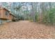 Large backyard with leaf covered ground and wooded area at 4065 Bent Oak Ct, Douglasville, GA 30135