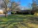 Front view of a one-story home with a grassy front yard, attached garage, and trees at 2228 Emerald Castle Dr, Decatur, GA 30035
