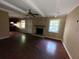 Living room with wood-look floors, brick fireplace, ceiling fan, and wood paneling at 2228 Emerald Castle Dr, Decatur, GA 30035