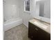 Bathroom with white tile, dark vanity, and bathtub at 4727 Garden Hills Dr, Stone Mountain, GA 30083